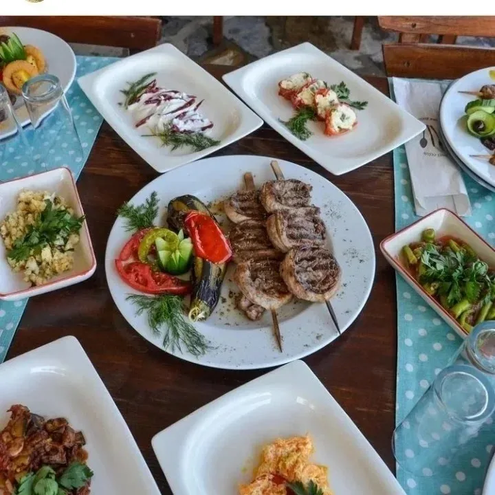 Skewered köfte with roasted peppers and side dishes