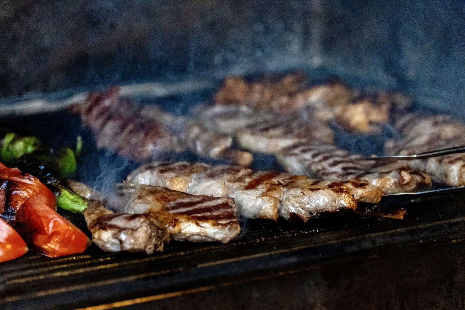 Meat grilling over the coals with onions and green peppers