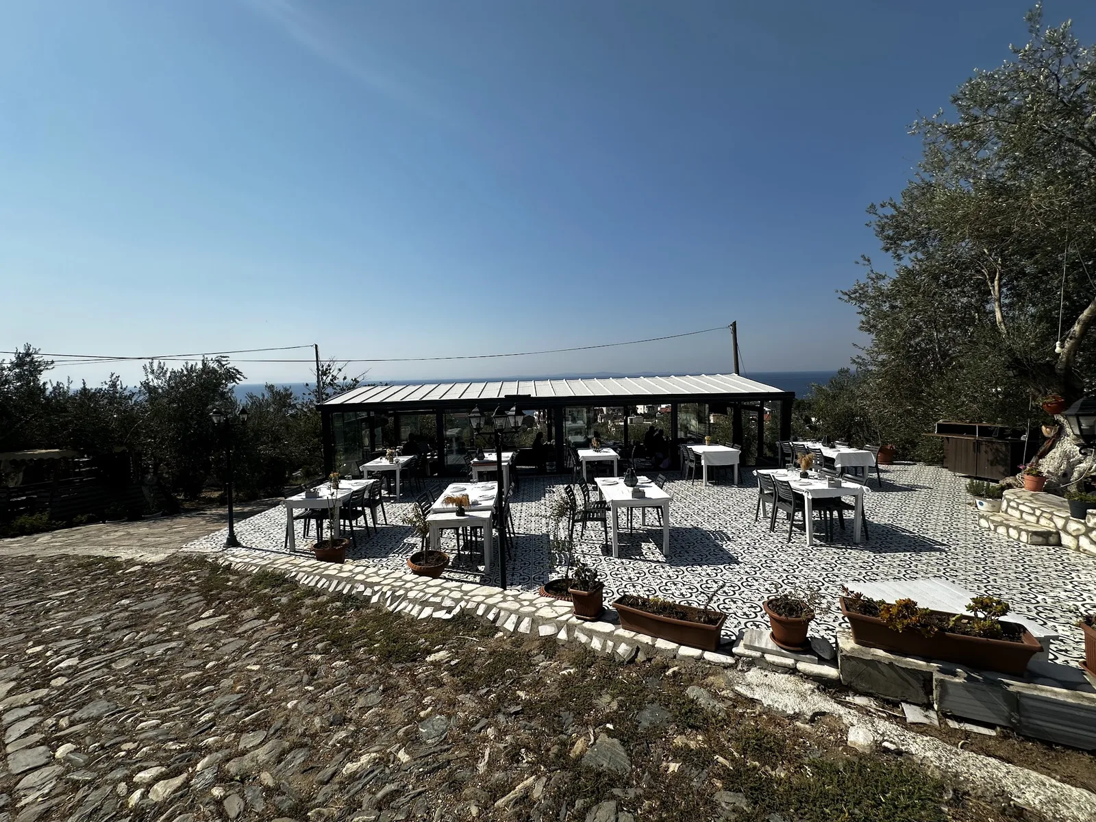 The hilltop terrace and glazed salon, with Küçükkuyu and the sea behind